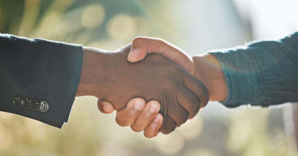 two people shaking hands with the background out of focus.