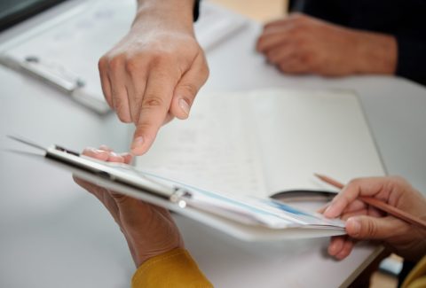 Closeup image of businessman pointing at chart in report, view from above
