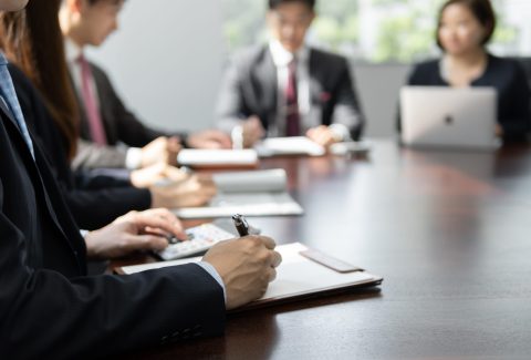 A businessperson having a meeting in a brightly lit conference room.