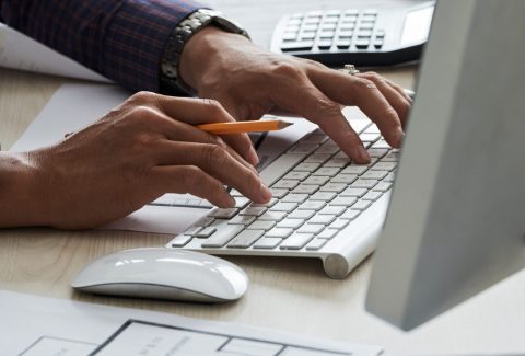 Hands of professional civil engineer working on computer in office